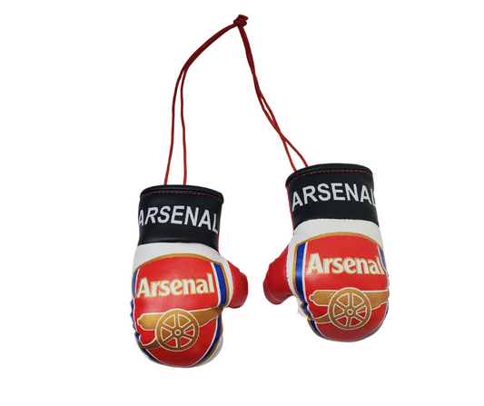 Set of mini Arsenal boxing gloves. Tied together with a red string. The red gloves have the official Arsenal crest with a gold cannon. Around the wrist of the gloves is a black band with white text reading "Arsenal."