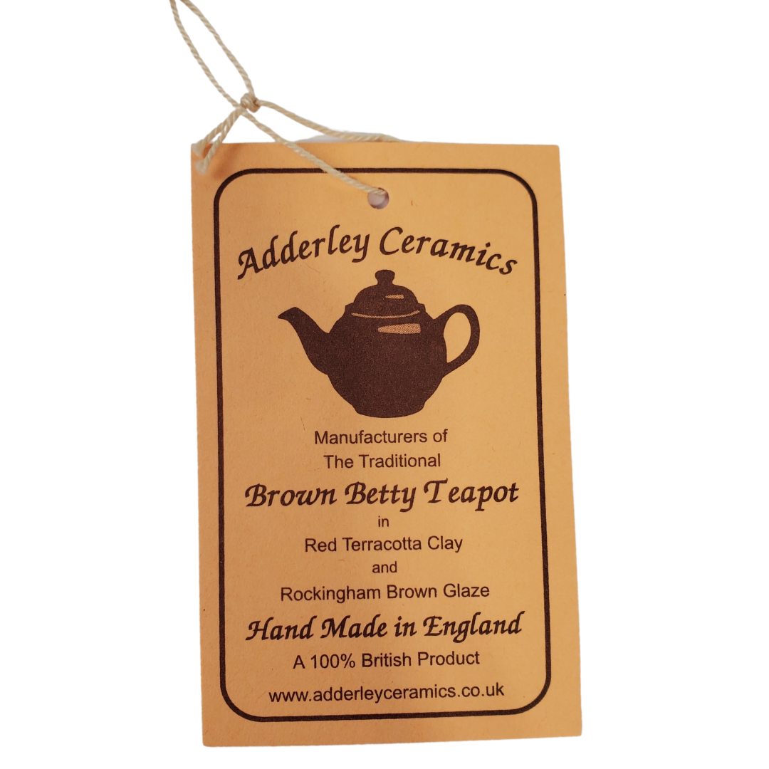 Close up Tag - During the reign of Queen Victoria, tea was a symbol of one of the greatest periods in Britain's history. Everyone owned a teapot in this era, many owning the "Brown Betty". Tea was no longer something the upper class could enjoy but became a household staple. This Brown Betty teapot is made from red terracotta and Rockingham glaze. Enjoy your perfect cup of tea without the worry of spiling with the specially designed spout. The Union Jack in the photo is a removable stick