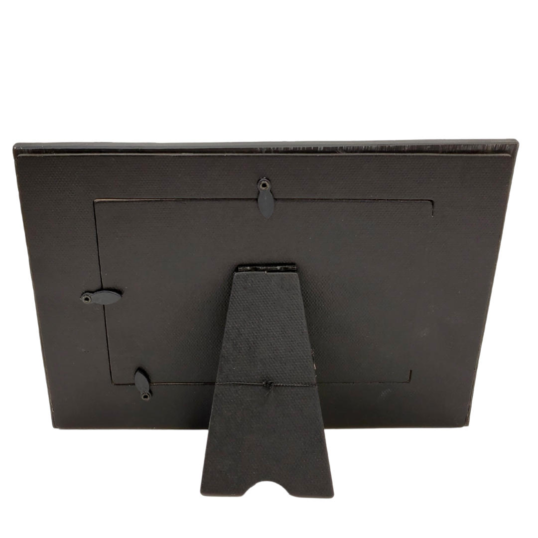 Back View of Frame - Give your pictures a touch of London with this London-themed picture frame. Perfect for any travel photos you would like to display! 9 x 0.8 x 6.5-inch photo frame is made of durable polyresin material. The frame is engraved with a bright red London on the top and features Big Ben on the left of the frame and a bright red 3D double-decker bus to the lower right. The frame holds a photo with 6 x 4" dimensions.