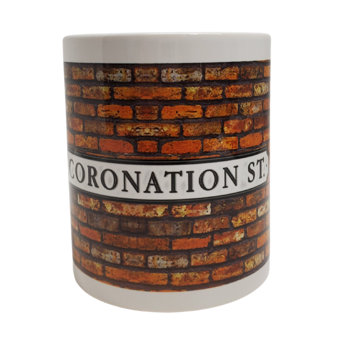 Enjoy your morning brew in our Coronation Street-themed coffee mug. This is the perfect gift for the Coronation Street lover in your life! Features the text "CORONATION ST" on a brick background on a white mug. Standard-sized coffee mug.  You can get a matching magnet for only $2.99 with the purchase of a mug! 