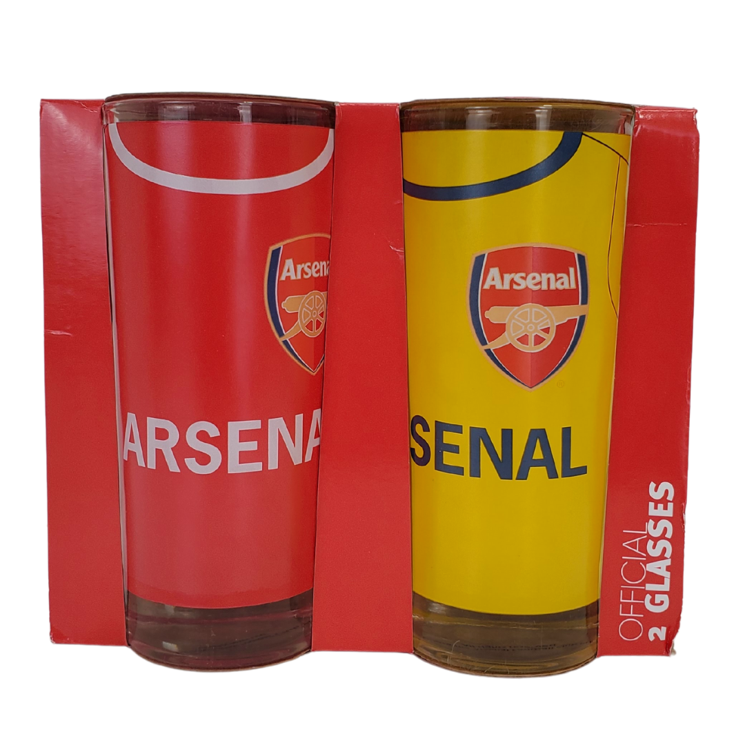 two official Arsenal football drinking glasses. The glass on the right is red with centered white test saying Arsenal. The glass on the right is yellow with centered text in navy blue saying arsenal. Both glasses have the official Arsenal crest. 