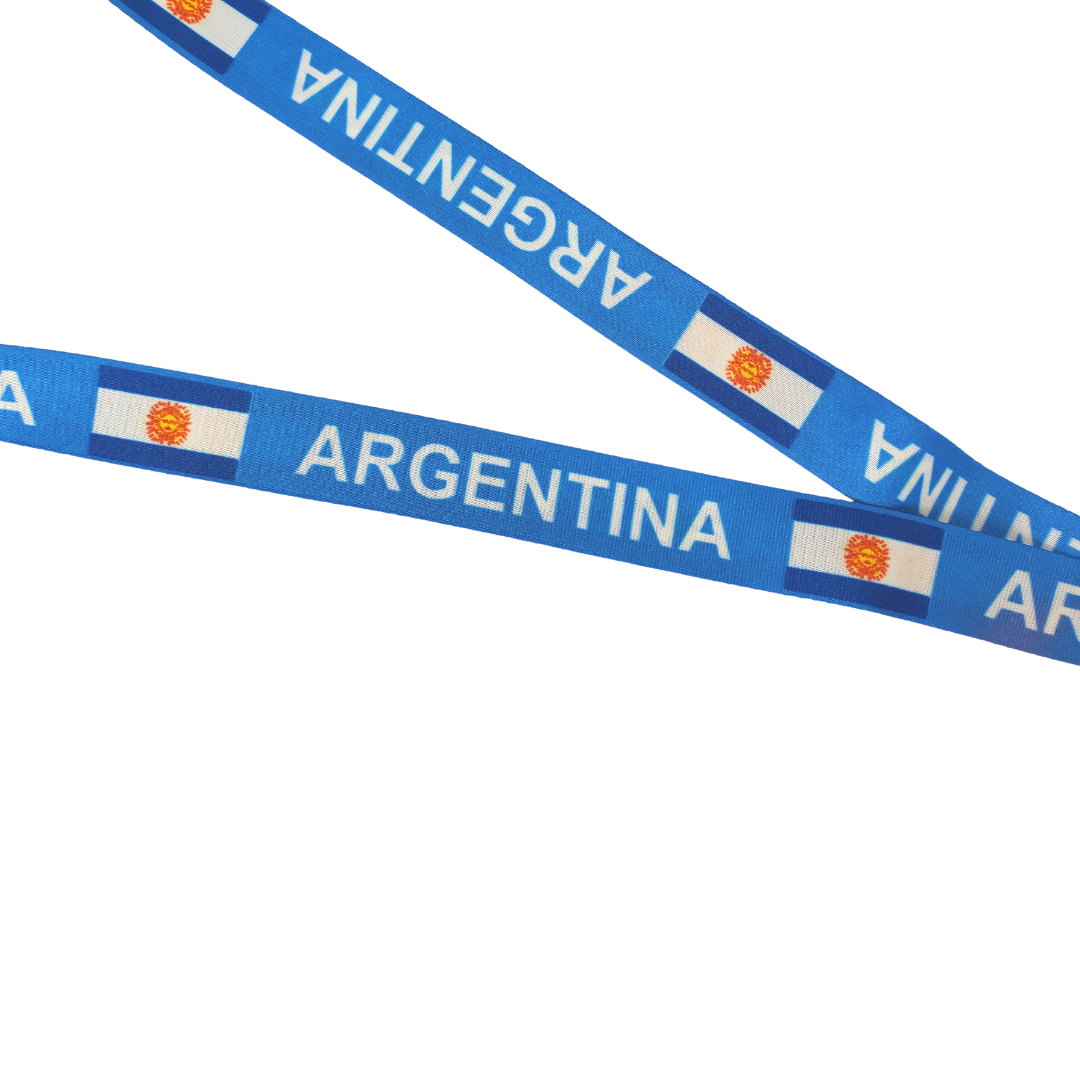 Close up image, Show off your Argentine heritage all while keeping your keys secured! Never lose your keys again with this stylish Argentina keychain lanyard. It showcases the beautiful national flag and the text "ARGENTINA." Comes with a metal clip as well as a fabric loop to secure an ID badge.