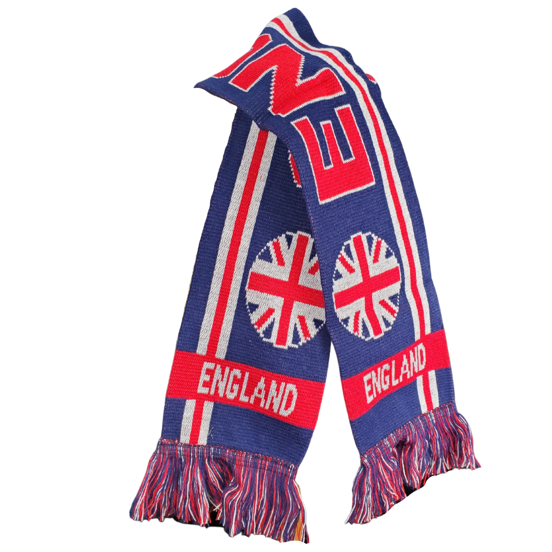 Stay warm when you are bundled up in this soft England scarf. This scarf has the beautiful deep blue, ruby red and white colour combination of the Union Jack. This long scarf has the text "ENGLAND" written across the length. At the ends are circular Union Jack flags and below them is the text "ENGLAND".