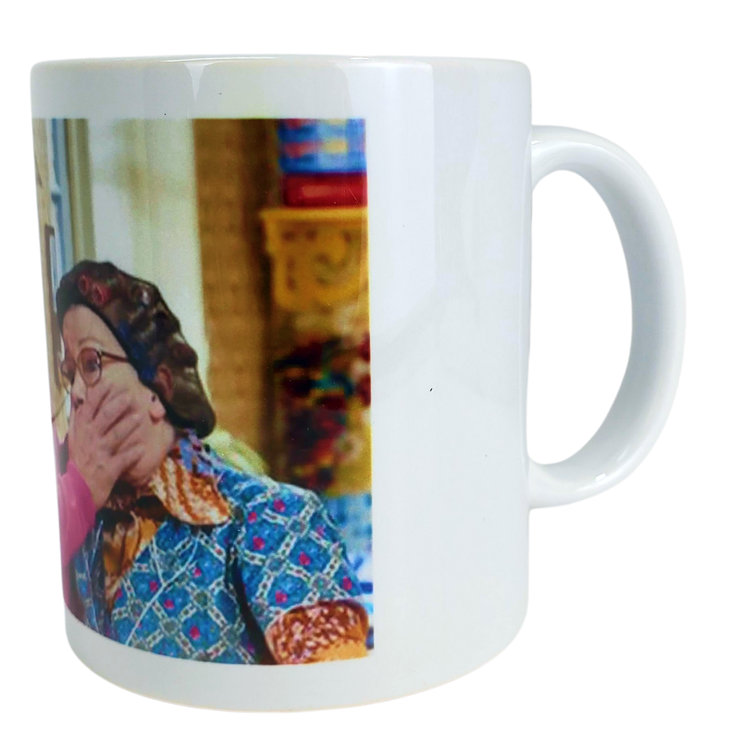 Close up view of handle - You're going to feckin' love this coffee mug! This coffee mug is perfect for the Mrs.Brown's boys fans! Featuring an image of Mrs.Brown covering the mouth of her counterpart. Standard-sized coffee mug.   EXTRA BONUS: Get the matching magnet for only $2.99 with purchase of mug!