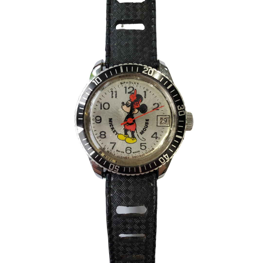 Vintage 1950's Bradley Mickey Mouse wristwatch. Swiss-made. Functioning but needs some work. Some light scratches on the face. 250/16s youth-sized rubber strap. Stainless steel back, water-resistant to 5ATM. Single tested Swiss-made base metal bezel.