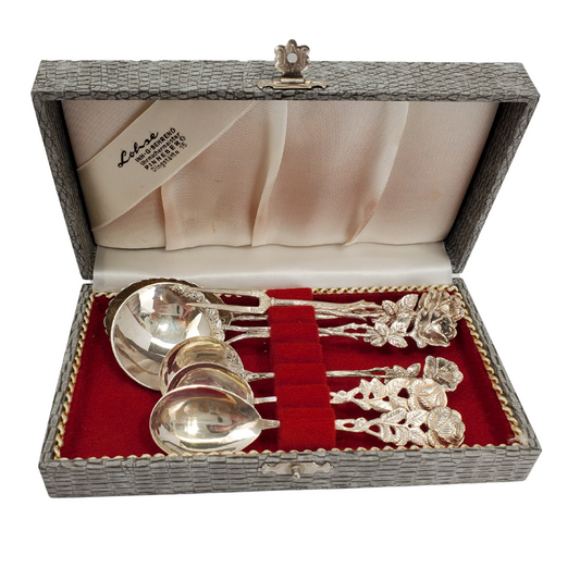 This gorgeous six-piece cutlery set is unlike any we have ever seen before. The set is made out of sterling silver in a beautiful rose design. The set comes in the original box lined with a bright red velvet. The box has a grey snake skin pattern and closes with a beautiful silver clasp. 