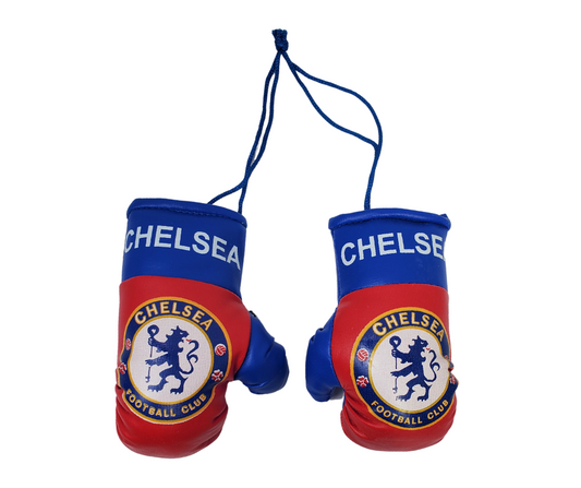 Set of official Chelsea football club mini boxing gloves. The gloves are tied together with a navy blue string. The gloves are red with blue thumbs and a blue band around the wrist. On the red portion is the official Chelsea logo. 