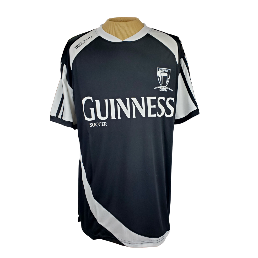 Black Guinness active T-shirt. Has white ribbon pattern down the side and on the arms. The text Guinness spans across the chest in white text. 