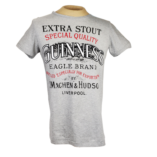 This is a soft grey shirt made with 100% cotton. The text across the front of the shirt reads "EXTRA STOUT SPECIAL QUALITY GUINNESS EAGLE BRAND BOTTLED ESPECIALLY FOR EXPORT BY C. MACHEN & HUDSON LIVERPOOL."   Care Instructions: Wash with like colours, do not iron.
