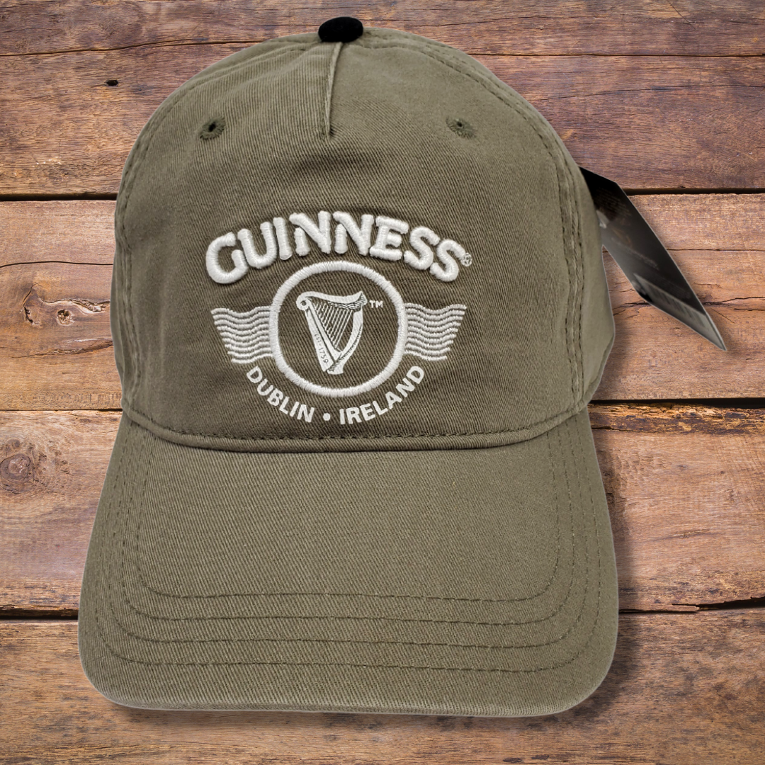 Army green Guinness ballcap. Has the text "GUINNESS" in the center. Below the text is the famous Guinness harp enclosed in a circle. Below the harp is the text "DUBLIN IRELAND" that curves along the bottom of the circle the harp is enclosed in.